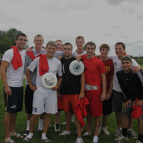 A frisbee team posing for a photo after practice.